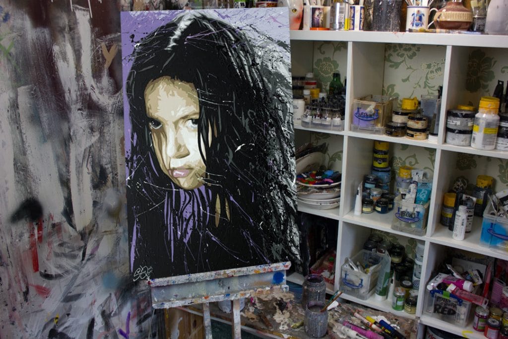river tam painting on a easel in a art studio