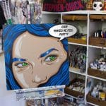 Feminist pop art painting of angry woman with glowing green eye and blue hair, acrylic on canvas