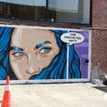 Stephen Quick painting the "Rage Makes Me Feel Pretty" mural at Upfest 2026 in Bristol